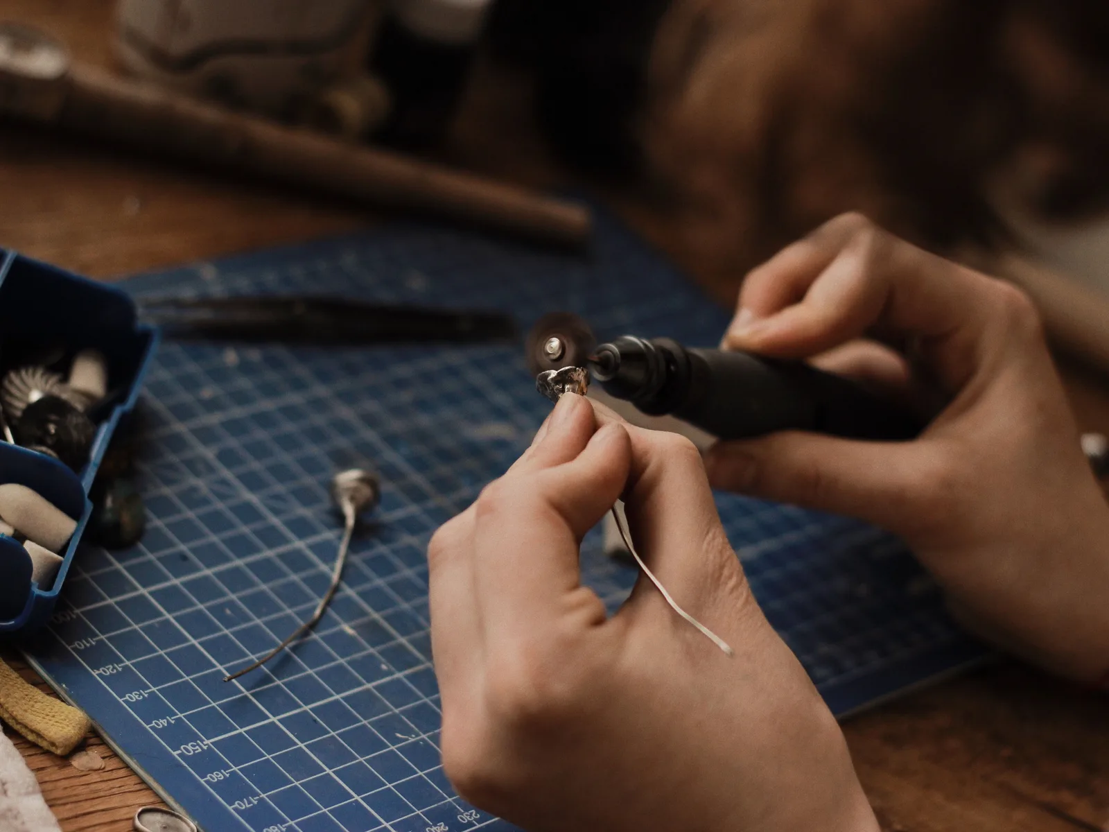 Artisan polishing silver jewelry with precision in a workshop setting. Workshop exposure controls compared for silver work