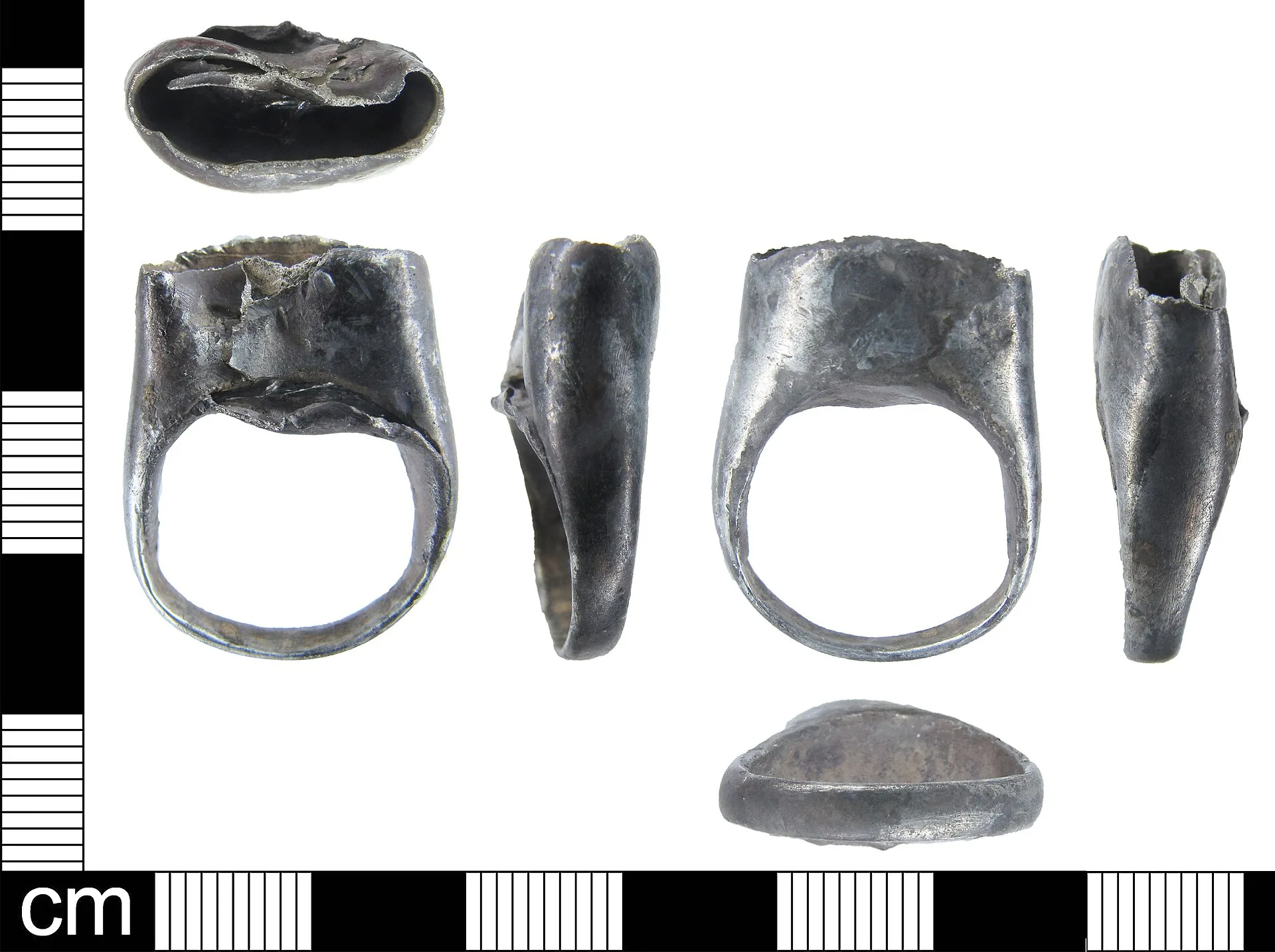 A silver finger ring with an empty bezel. The ring is undecorated and the band is D-shaped in cross-section. The bezel extends straight up from one side of the ring and would have been oval in shape but has been squashed. The setting is quite deep (c. 8mm) and retains no traces of what was set in it. Rebuild undersized silver bezel: replacement decision