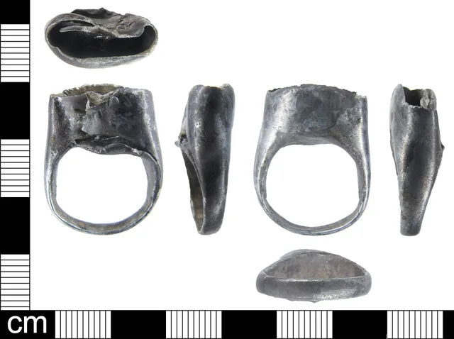 A silver finger ring with an empty bezel. The ring is undecorated and the band is D-shaped in cross-section. The bezel extends straight up from one side of the ring and would have been oval in shape but has been squashed. The setting is quite deep (c. 8mm) and retains no traces of what was set in it. Rebuild undersized silver bezel: replacement decision