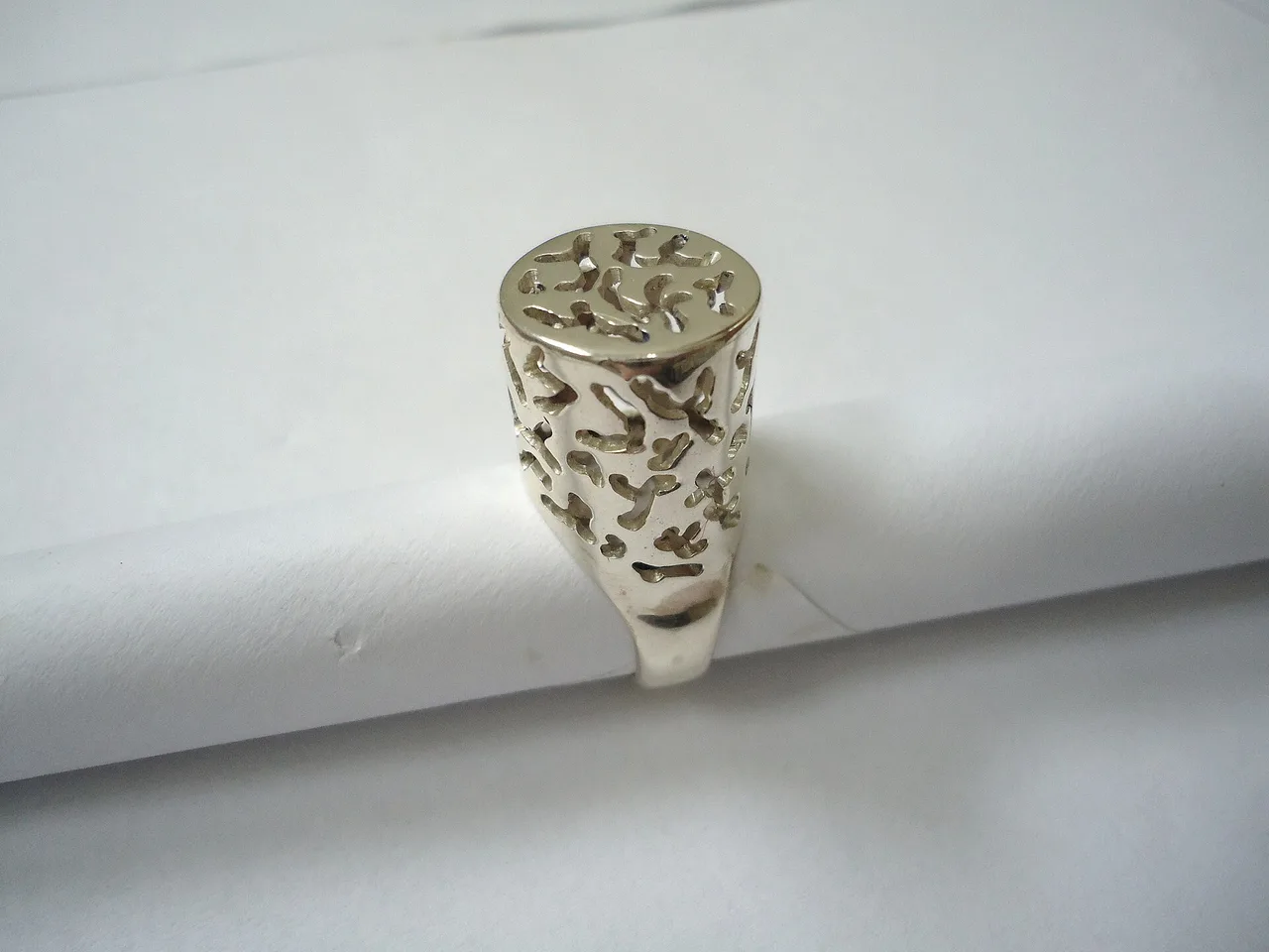 Silver ring with repeated pierced openings across its upper surfaces