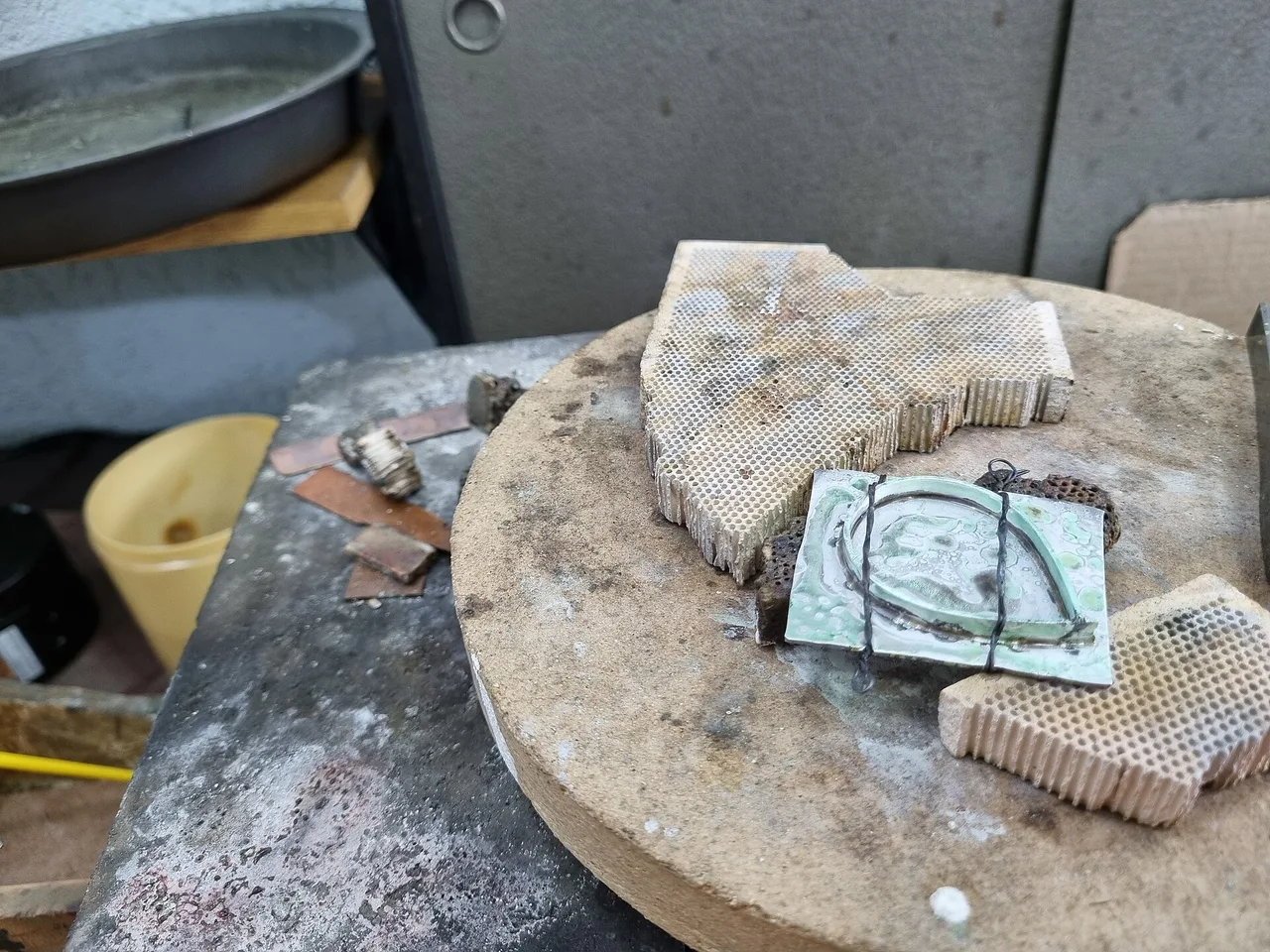 Silver bezel assembly secured on a heat-resistant soldering surface