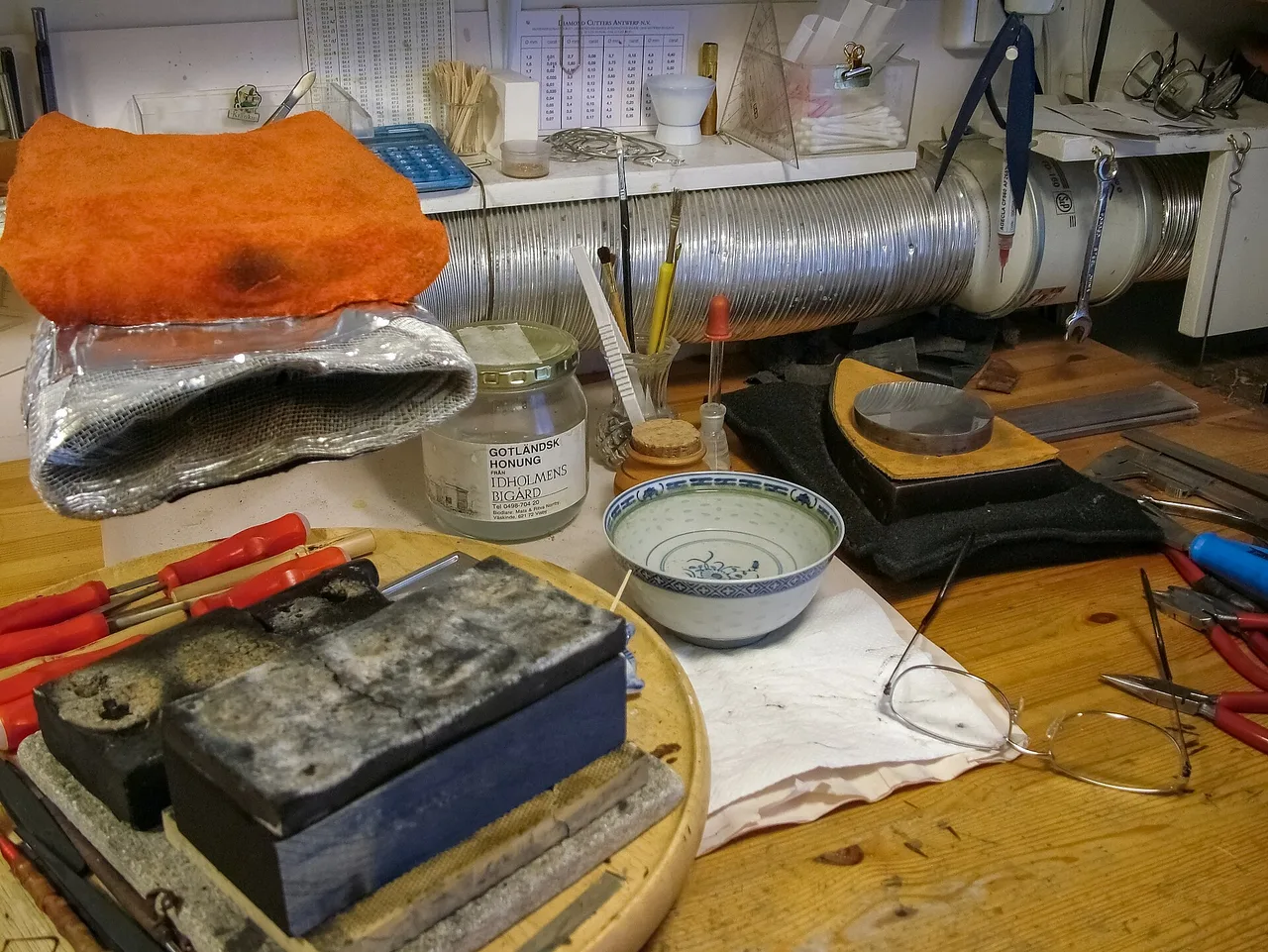 Hard-soldering station with heatproof blocks, tools, and an exhaust duct